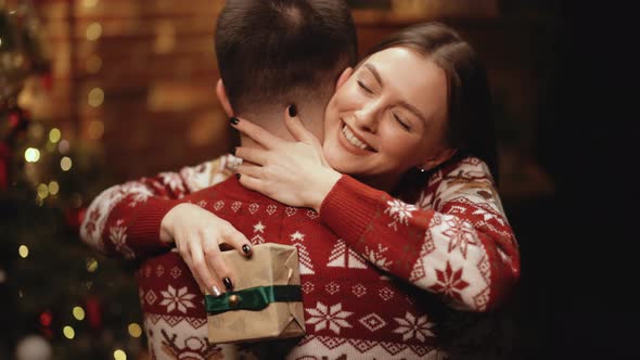 Close Up of Young Beautiful Woman Hugging Man Holding Christmas Present