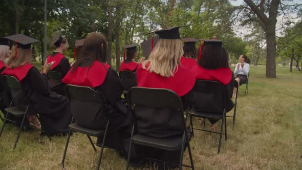 Positive Multiethnic Graduates Applauding to Dean Speech at Graduation Day alt