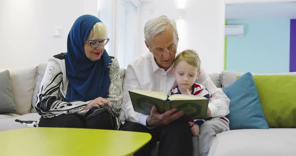 Muslim Family Generations Grandparents Reading Quran with Grandchildren at Home alt