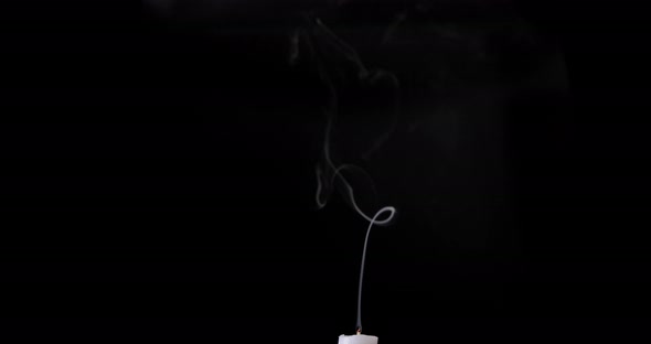 White smoke isolated on black background. White smoke slowly floating up from the white candle alt