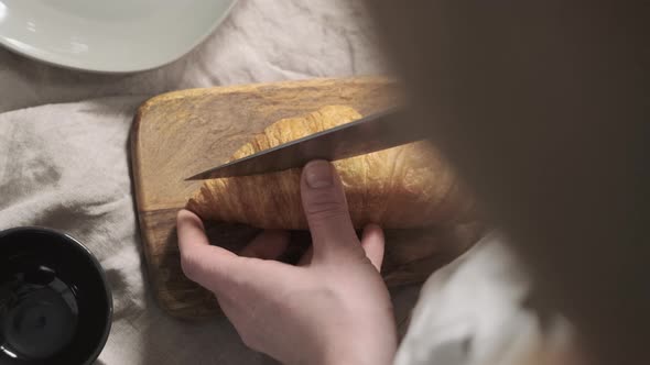 Top Down View of Woman Chef Cuts Croissant