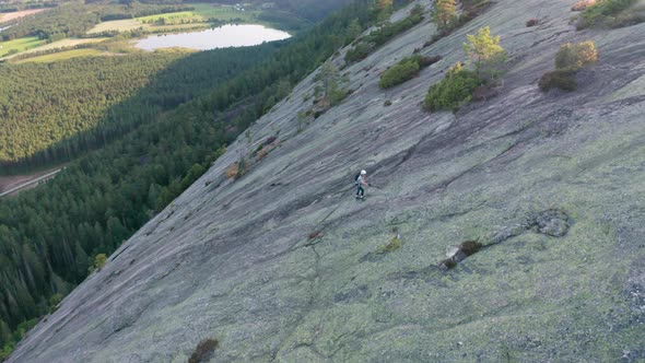 Drone Of Rock Climber Using Ropes To Climb Mountain Slope alt