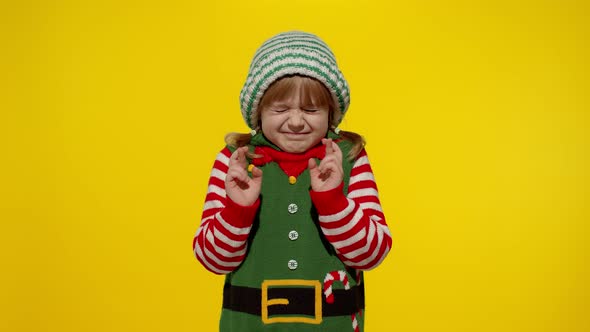 Christmas wish concept Kid teen girl in Christmas elf Santa helper costume making a wish, prays alt