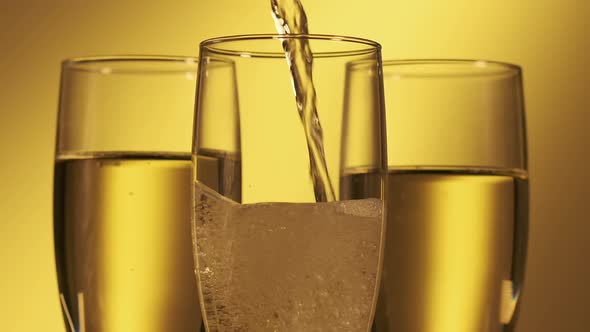 Pouring Champagne Wine Into Glasses, Champagne at Yellow Background alt
