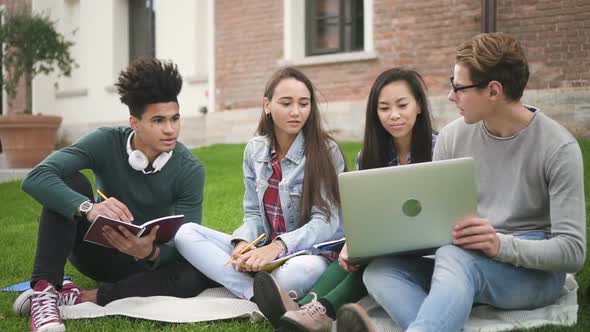 Medium Shot of Adult Multiethnic American Friends Man and Woman Group Using Laptop Technology alt