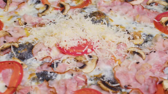Close Up View of a Chef Sprinkling Fresh Cilantro on a Cooked Pizza alt