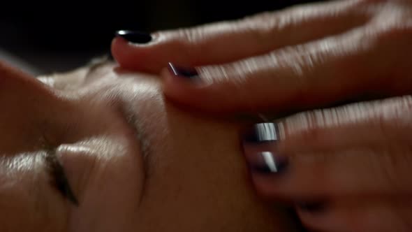 Close Up of Massage Therapist Hands Massaging Female Forehead alt