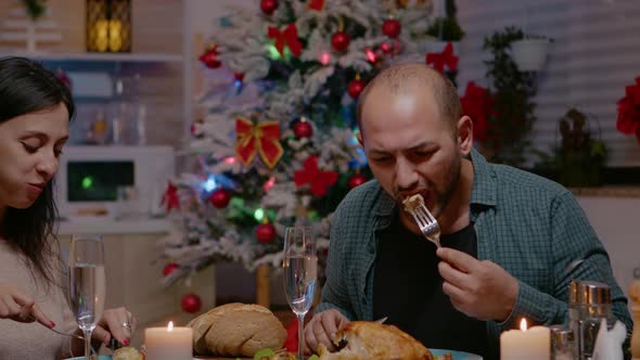 Festive Couple Enjoying Christmas Dinner and Clinking Glasses alt