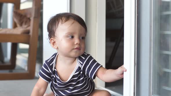 A Cute 810 Month Old Baby Explores the World and Learns the Work of Opening a Sliding Door By