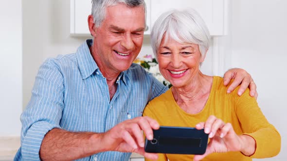 Mother and daughter embracing each other in living room alt
