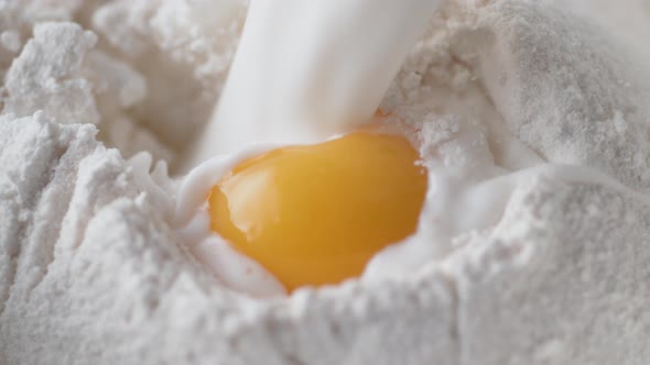 Pouring milk on an eeg and a pile of flour. Slow Motion. alt