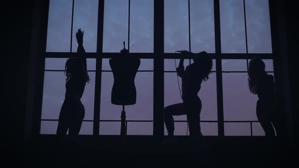The Women's Music Group Is Filmed in a Music Video. They Dance and Sing in the Background of a Large alt