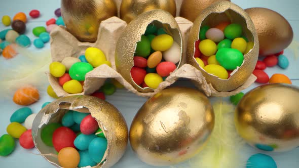 Golden Decorative Easter Eggs Filled with Colorful Candies on Wooden Table Close Up