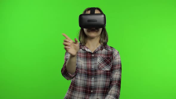 Girl Using VR App Helmet To Play Simulation Game. Slide Gestures. Watching Virtual Reality 3d Video alt