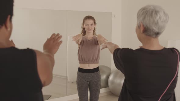 Fitness Trainer Showing Exercises to Mature Women alt