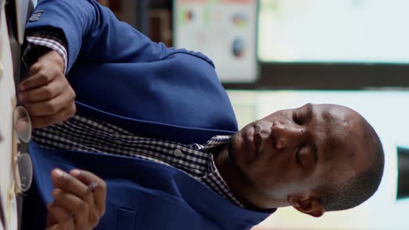 Vertical Video Male Consultant Using Paperwork to Develop Business Strategy alt