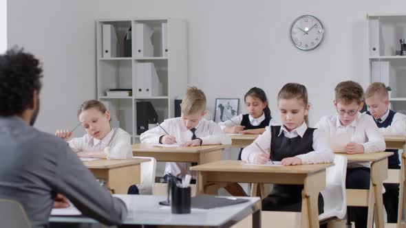 Primary School Pupils Writing Test in Classroom alt