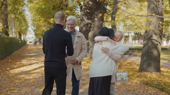 Adult Parents and Young Children Meeting in Autumn Park Spending Weekend Together alt