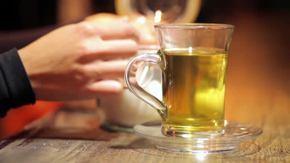 Tea glass and a spoon adding some sugar