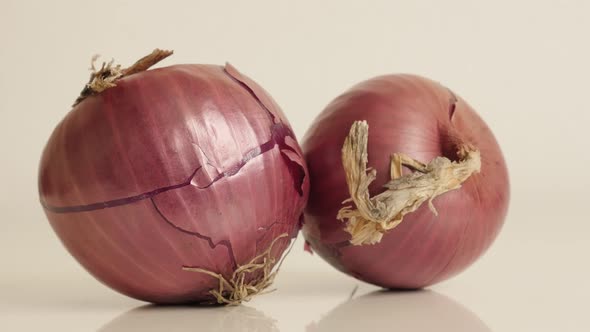 Pair of onions with red skin and white flesh close-up 4K 2160p 30fps UltraHD tilting footage - Organ alt