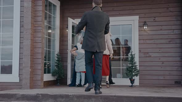 Family with Kids Comes in the House of Grandparents to Celebrate Christmas alt