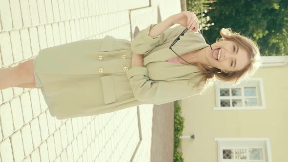 Young beautiful smiling hipster girl in trendy summer clothes posing outdoors alt