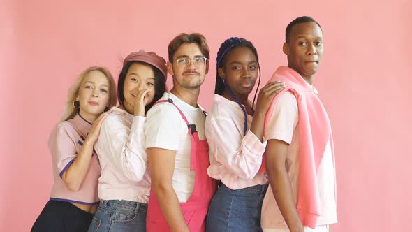 Portrait of Young Diverse People Leaned on Each Other Isolated on Pink Background. alt