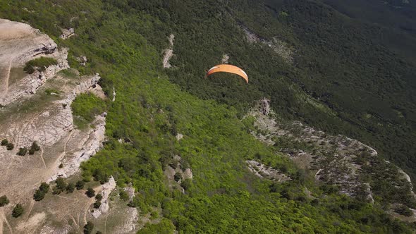 Paraglider Flies Over the Surface of the Earth in the Mountains of Crimea alt