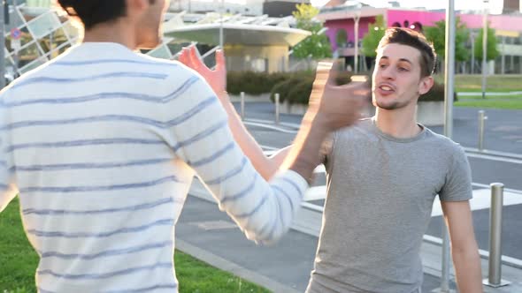 two young men outdoor handshaking smiling alt