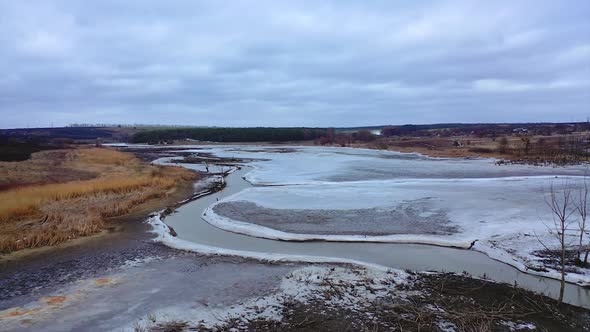 Environmental problems. Frozen river on a dirty background of nature.  alt