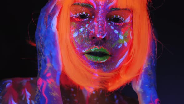 Sexy Girl with a UV Pattern on Her Body and an Orange Wig Dancing in the Dark alt