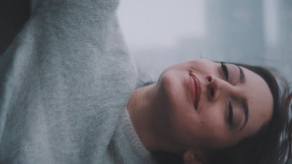 A woman enjoying the wind and the snow on her terrace alt