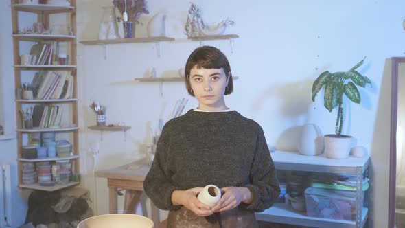 Portrait of pottery woman in her workshop