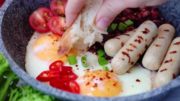 Eating with Bread Fried Eggs, Sausages and Beans - Breakfast in Pan. Homemade Breakfast Concept.