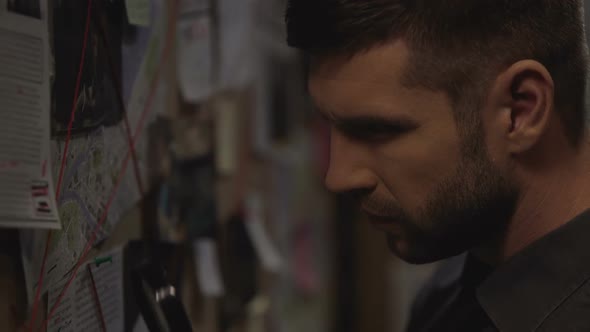 Serious Policeman Searching for Location on City Map With Magnifying Glass alt