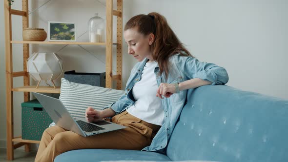 Surprised Young Woman Getting Good News Using Laptop Showing Thumbsup and Raising Arms at Home alt