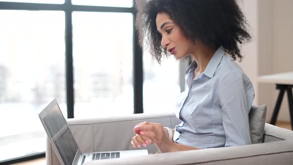 A Young Biracial Woman is Using a Laptop for Video Connection Indoor alt