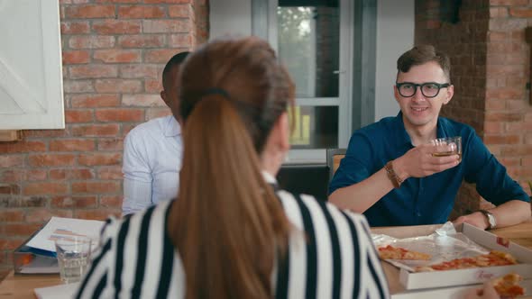 Business Team Enjoy Eating Pizza Lunch Together at Work in Loft Office