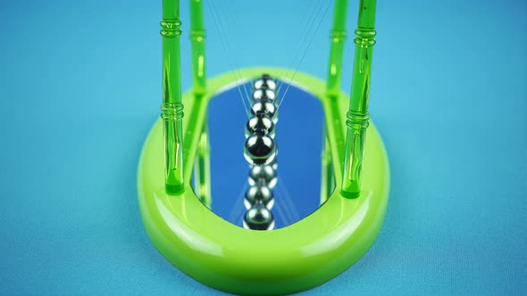 Green Pendulum Balls Newton On A Blue Background.