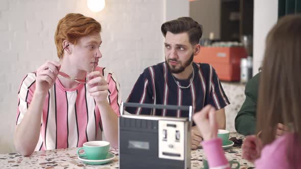 Disinterested Young Men with Shocked Facial Expression Listening to Blurred Woman Talking alt
