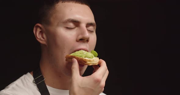 Young Man Enjoys Eating A Sandwich Of Fresh Homemade Avocado Bread