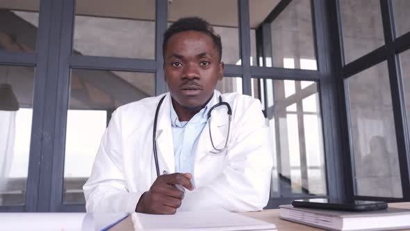 African Male Doctor Consulting Patient During Virtual Telemedicine Advice alt