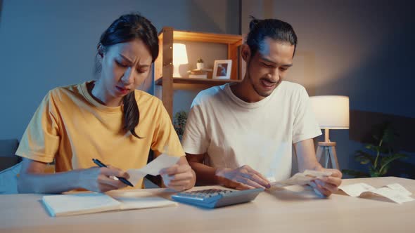 asia man and woman use calculator for calculate family budget debts monthly expenses. alt