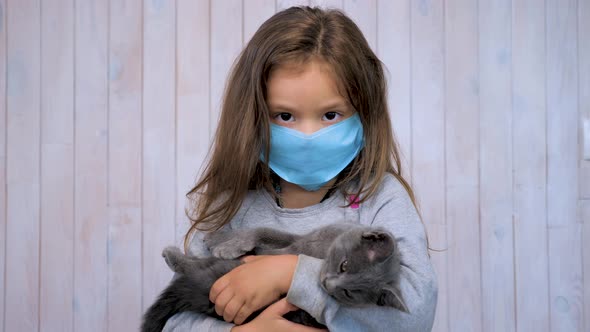 Regions of the Red Zone. Girl with a kitten in a medical disposable mask. Wearing a face mask
