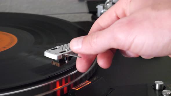A record player needle raising slowly off of the spinning vinyl and the music stops. alt