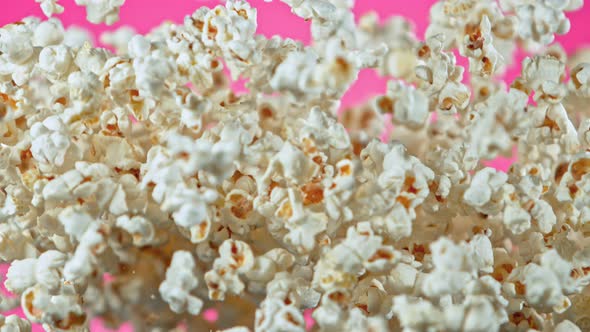 Super Slow Motion Shot of Popcorn on Pink Background After Being Exploded at 1000Fps alt