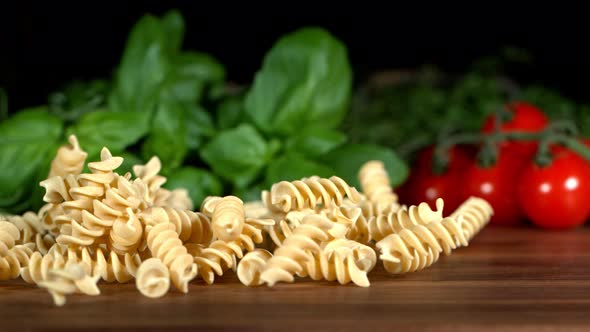 Super Slow Motion Shot of Fresh Fusilli Falling on Italian Decorated Wooden Table at 1000Fps alt