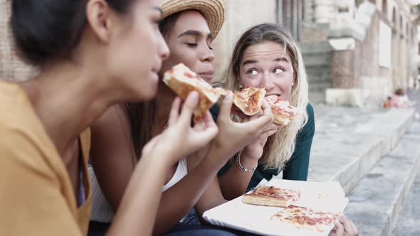 Three Multiracial Women Eating Pizza Enjoying Holidays Together in Italy alt