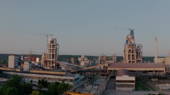 Cement Plant with High Factory Structure at Industrial Production Area at Sunset alt
