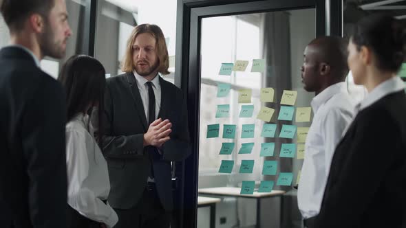Business Meeting International Management Team at Work Team Is Standing Next To a Glass Board with alt